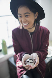 A young woman holding a handful of coins