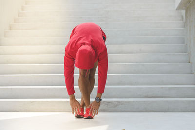 Woman touching toes while exercising by steps