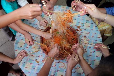 High angle view of people sharing noodles