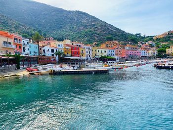 Scenic view of town by sea against sky