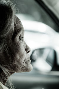 Close-up of woman looking away in car