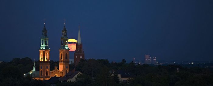 Illuminated buildings in city against sky