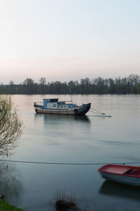Boats moored on lake against clear sky