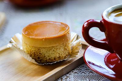 Close-up of coffee cup and custard cake on table