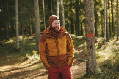 Smiling man standing in forest
