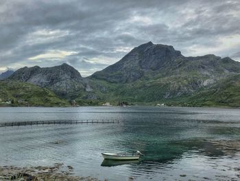 Scenic view of lake by mountains against sky