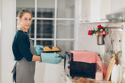 Portrait of woman with vegetables on table at home