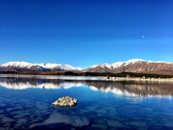 Scenic view of lake and mountains against clear sky