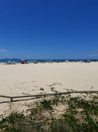 Scenic view of beach against clear blue sky