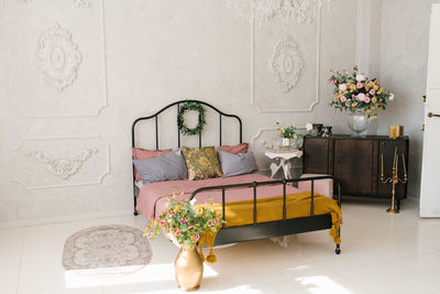 Neoclassical bedroom interior. a bed with a pink bedspread and gray pillows. flowers in a vase 