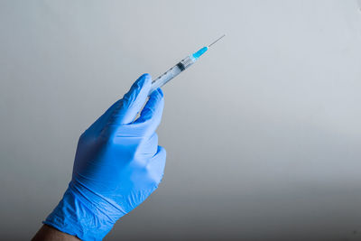 Cropped hand of doctor holding syringe