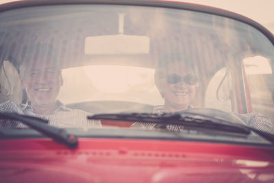 Cheerful senior couple traveling in car