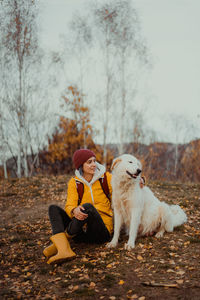 Portrait of woman with dog on field