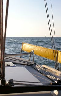 Sailboat in sea against clear sky