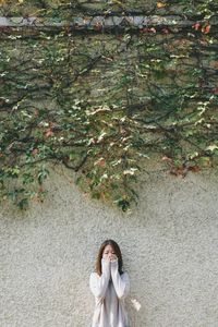 Portrait of woman standing by tree