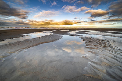 Scenic view of beach against sky during sunset