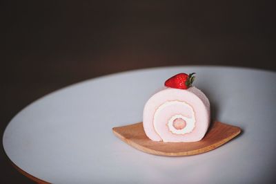 Close-up of swiss roll with strawberry served in plate