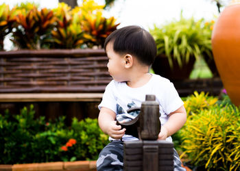 Baby boy looking over shoulder in park