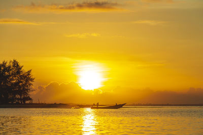 Silhouette of fisherman catching fish early in the morning at laem ta chi, pattani, thailand