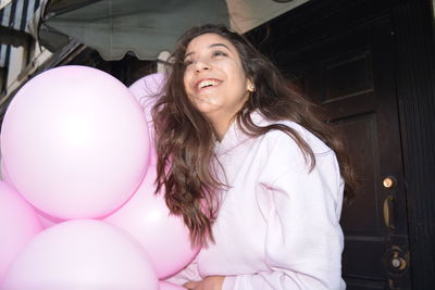 Portrait of woman with pink balloons