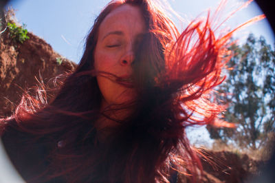 Portrait of young woman with sky in background