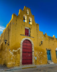 Low angle view of old building against clear blue sky