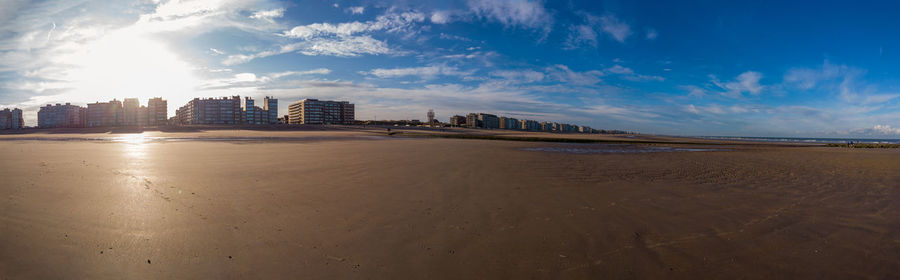 Panoramic view of beach and buildings against sky