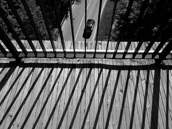 High angle view of railing by shadow on footpath