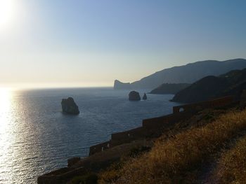 Scenic view of sea and mountains at sunset