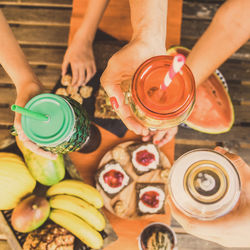 High angle view of people preparing food and cold natural drink on table