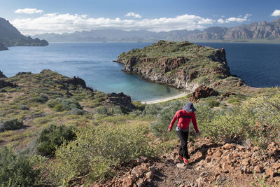 One woman hiking on a trail in del carmen island at loreto bay