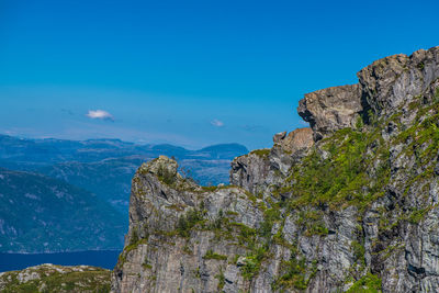 Low angle view of rocks against blue sky