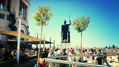 People in front of built structure against clear sky