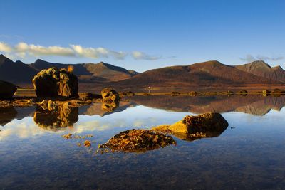 Scenic view of lake by mountains against sky