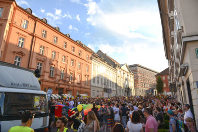 Crowd on street in city against sky