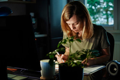 Woman works at home office remotely, using computer