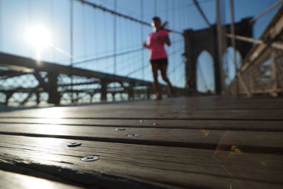 Full length of woman standing by railing against bridge