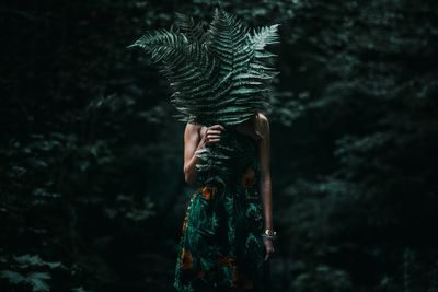 Midsection of person standing by tree