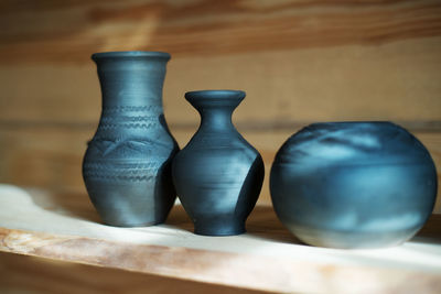 Close-up of pots on shelf at workshop