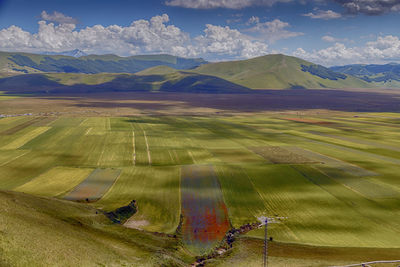 Scenic view of field and mountains against sky