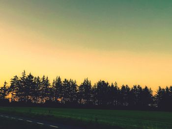 Scenic view of field against clear sky during sunset