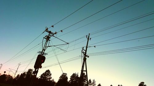 Low angle view of electricity pylon against clear sky