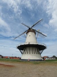 Traditional windmill on field against sky