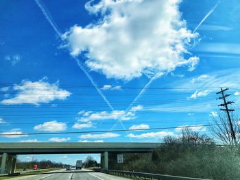 Low angle view of electricity pylon against blue sky