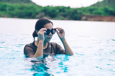 Mid adult woman wearing sunglasses in sea