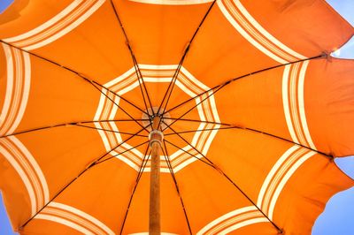 Low angle view of open beach umbrella against sky