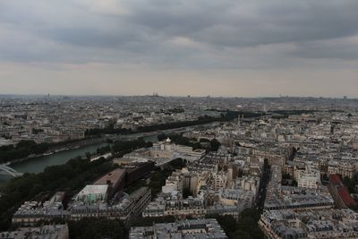 Aerial view of cityscape against cloudy sky