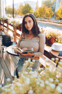 Portrait of beautiful woman reading a book while relaxing in the cafe.