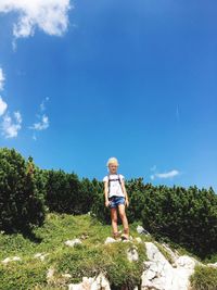 Full length of boy standing on plants against sky