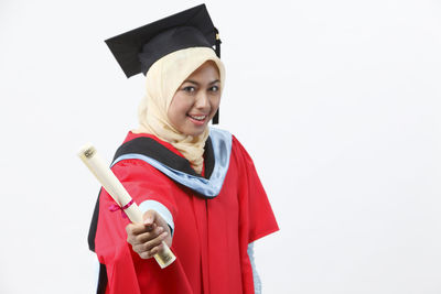 Portrait of smiling young woman holding umbrella